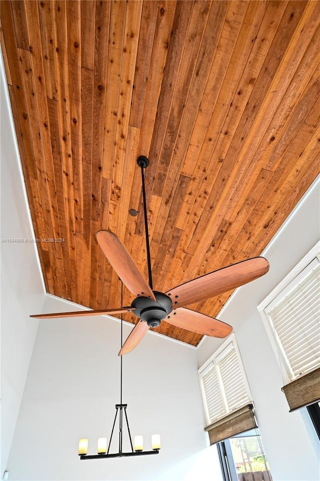 interior details featuring ceiling fan with notable chandelier and wood ceiling