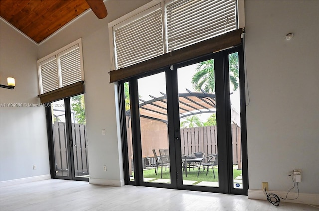 doorway to outside with light hardwood / wood-style floors, wood ceiling, and high vaulted ceiling