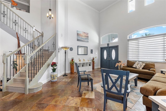 living room with a high ceiling, an inviting chandelier, plenty of natural light, and ornamental molding