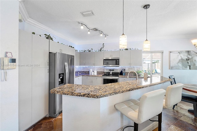 kitchen with stainless steel appliances, decorative light fixtures, a textured ceiling, decorative backsplash, and ornamental molding