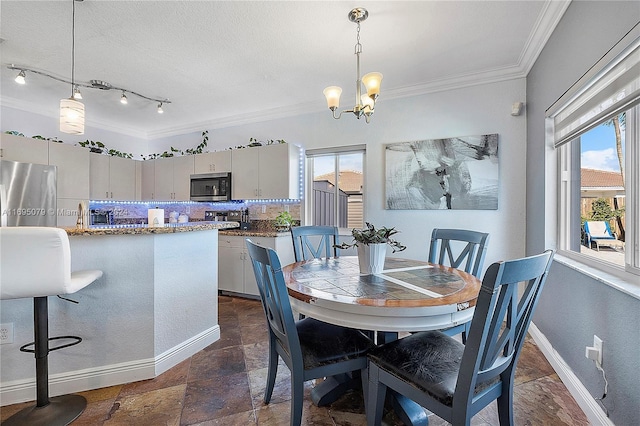 dining room with a wealth of natural light, crown molding, and a notable chandelier