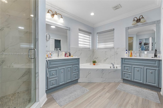 bathroom with hardwood / wood-style floors, vanity, separate shower and tub, and ornamental molding