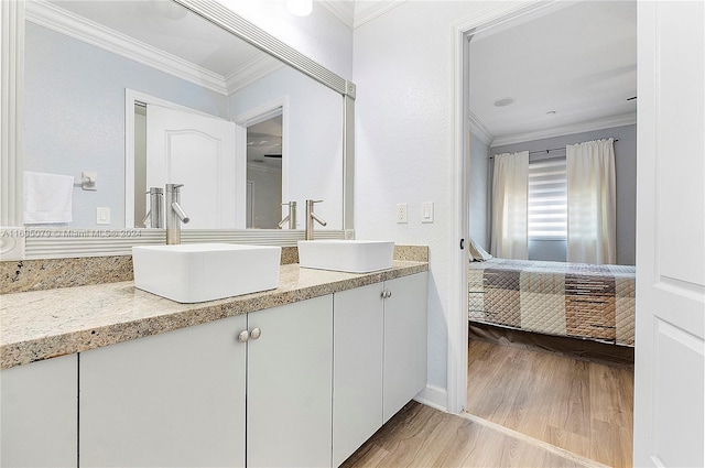 bathroom with vanity, wood-type flooring, and ornamental molding