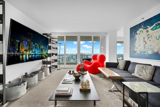 living room featuring carpet, a healthy amount of sunlight, and a wall of windows