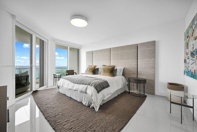 bedroom with access to outside, a water view, light tile patterned floors, and a wall of windows