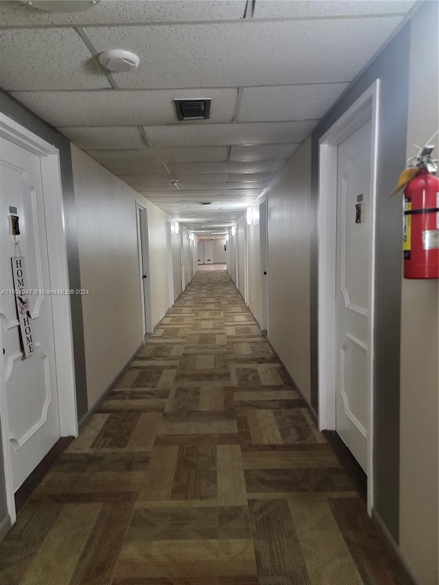 hallway with a paneled ceiling