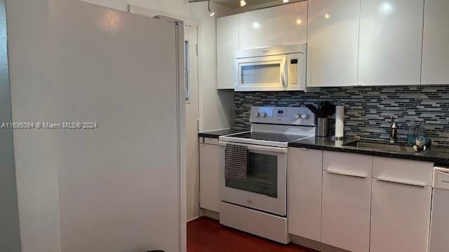 kitchen featuring white cabinets, white appliances, and backsplash