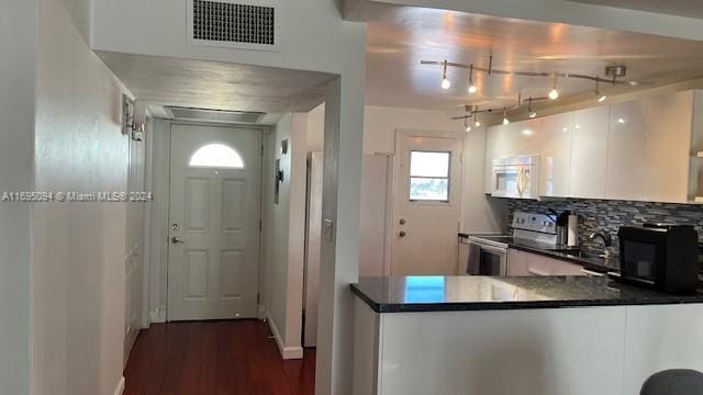 kitchen featuring backsplash, dark wood-type flooring, sink, white cabinets, and stainless steel range with electric cooktop