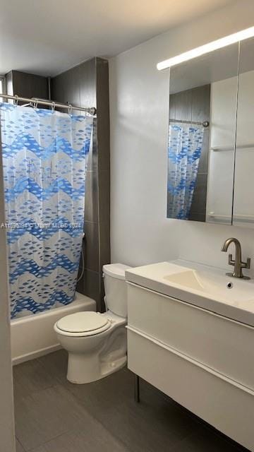 full bathroom with tile patterned flooring, shower / bath combination with curtain, toilet, and vanity