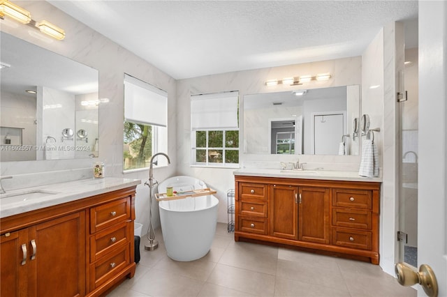 bathroom with tile patterned floors, vanity, a textured ceiling, tile walls, and shower with separate bathtub