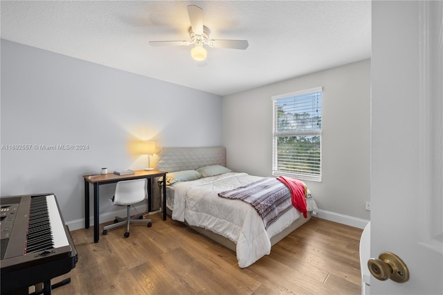 bedroom featuring hardwood / wood-style floors, a textured ceiling, and ceiling fan