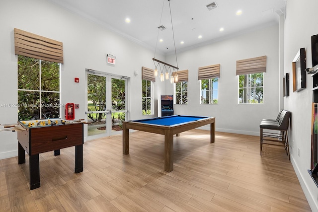 recreation room featuring french doors, a high ceiling, light hardwood / wood-style flooring, crown molding, and pool table