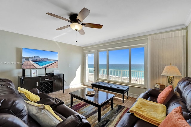 living area with a ceiling fan, light wood-type flooring, crown molding, and baseboards