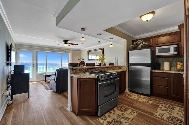 kitchen with electric range, dark wood-style floors, freestanding refrigerator, a peninsula, and built in microwave