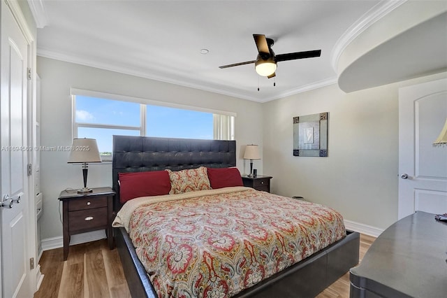 bedroom with baseboards, ceiling fan, wood finished floors, and crown molding