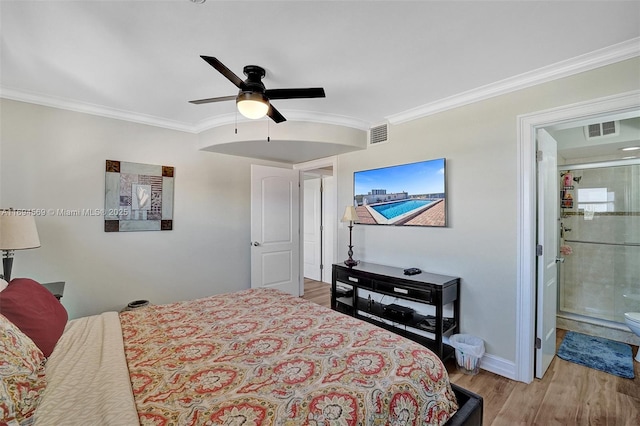 bedroom with baseboards, wood finished floors, visible vents, and crown molding