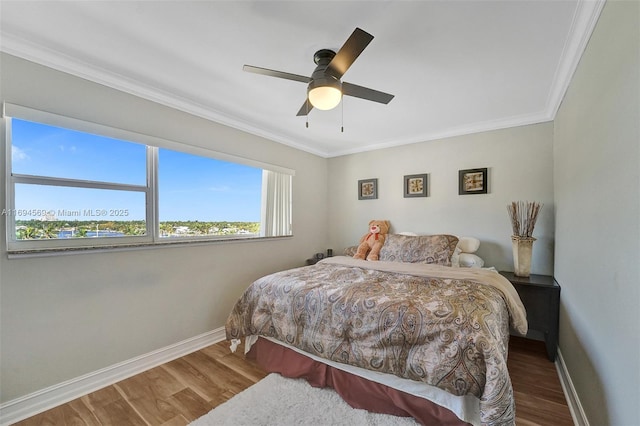 bedroom with a ceiling fan, baseboards, wood finished floors, and ornamental molding