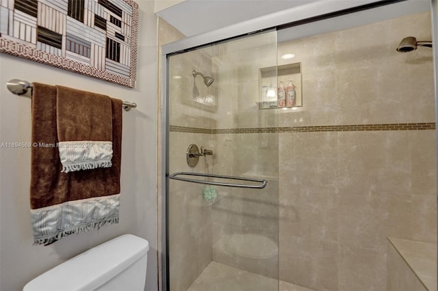 bathroom featuring a shower stall and toilet