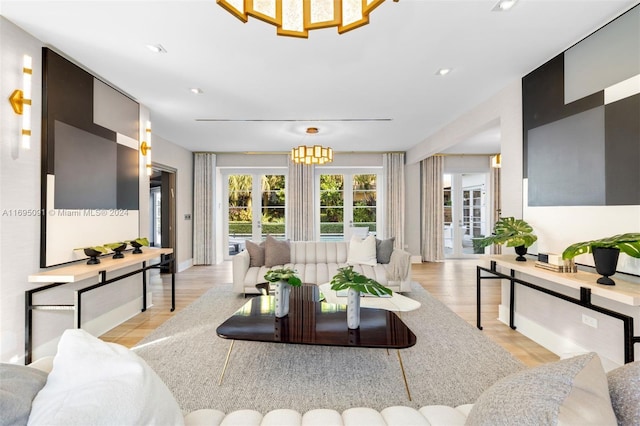 living room featuring a chandelier, light hardwood / wood-style floors, and french doors