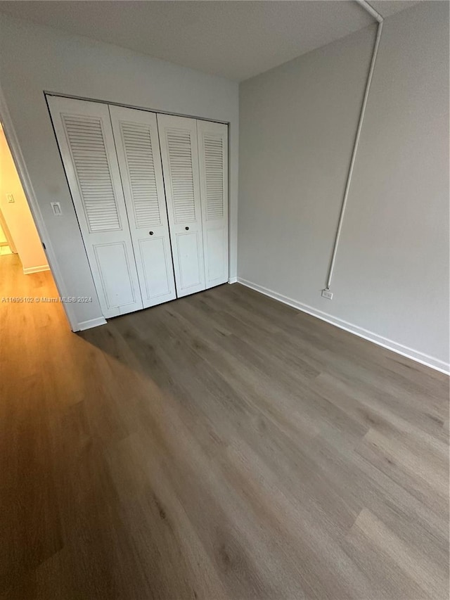 unfurnished bedroom featuring hardwood / wood-style flooring and a closet