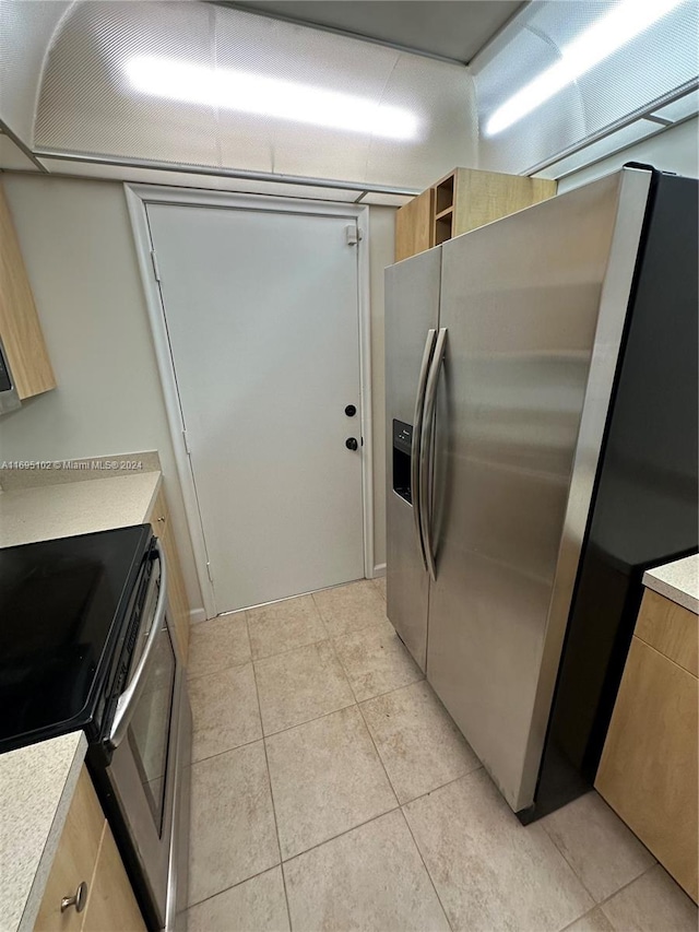 kitchen featuring light tile patterned flooring and appliances with stainless steel finishes