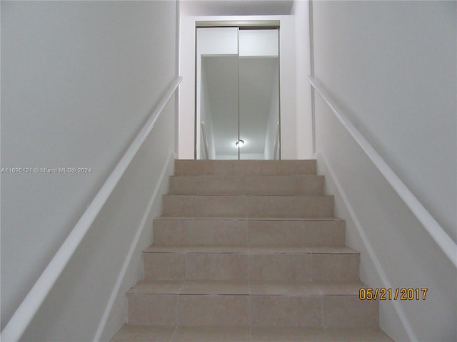 stairway with tile patterned flooring