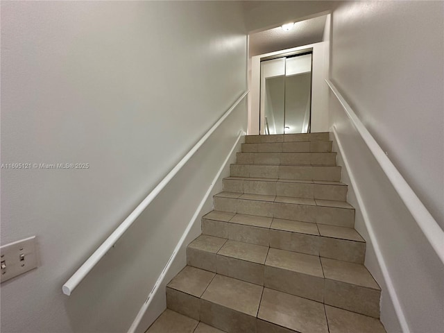 stairway featuring tile patterned flooring