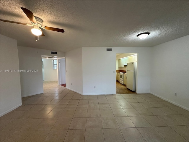 unfurnished room featuring baseboards, visible vents, ceiling fan, a textured ceiling, and tile patterned floors