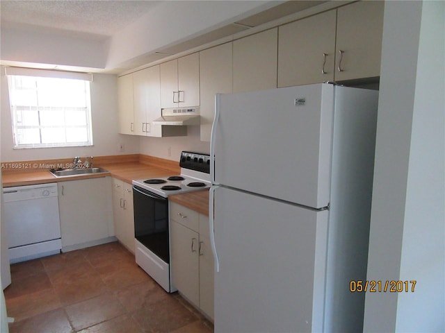 kitchen featuring white cabinets, white appliances, sink, and a textured ceiling