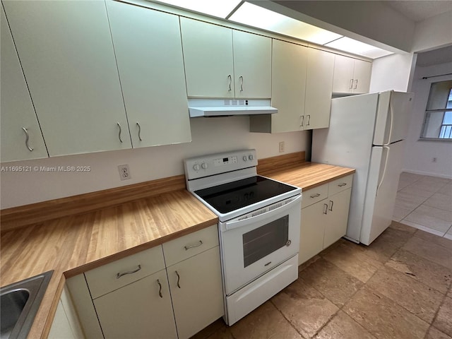 kitchen with under cabinet range hood, butcher block countertops, stone finish floor, white appliances, and a sink