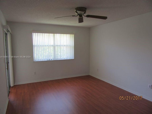 spare room featuring ceiling fan, dark hardwood / wood-style flooring, and a textured ceiling