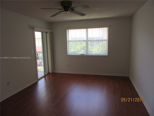 spare room with ceiling fan, dark wood-type flooring, and a healthy amount of sunlight