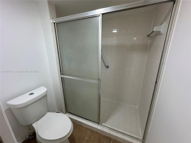 bathroom featuring a shower stall and toilet