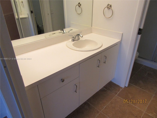 bathroom featuring tile patterned flooring, vanity, and toilet