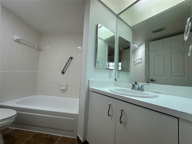 bathroom with visible vents, toilet, vanity, and washtub / shower combination