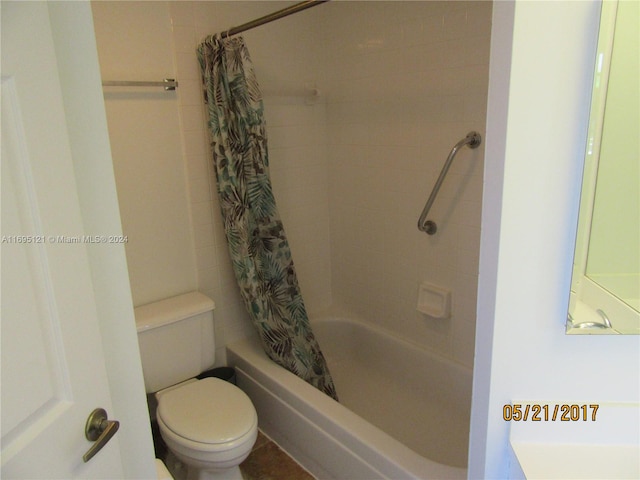 bathroom featuring shower / bathtub combination with curtain and toilet