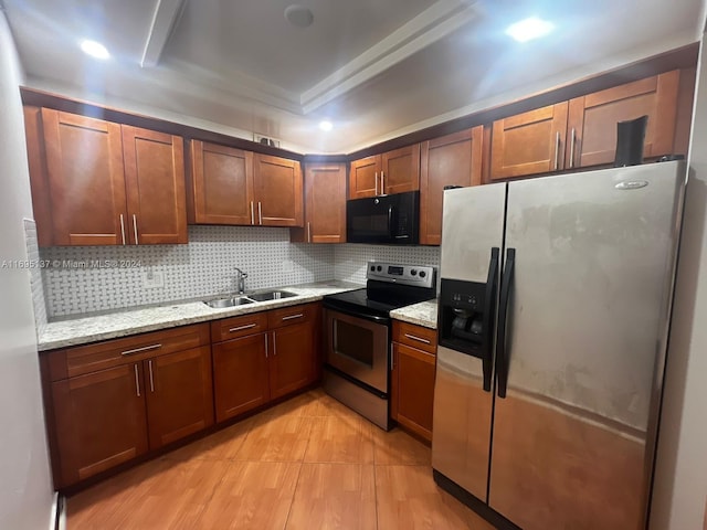 kitchen with decorative backsplash, light stone counters, stainless steel appliances, sink, and light hardwood / wood-style floors