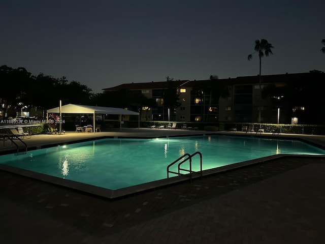 view of pool at twilight