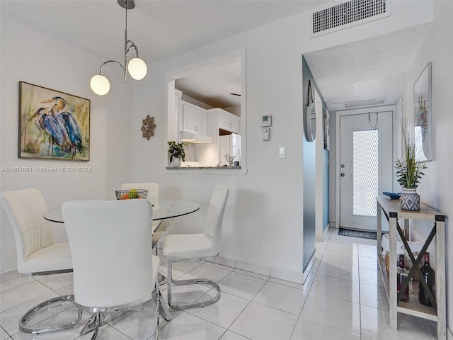 tiled dining area featuring a textured ceiling