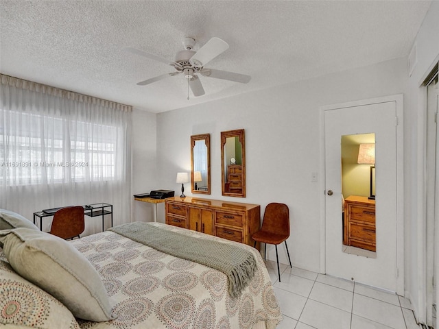 tiled bedroom featuring ceiling fan and a textured ceiling