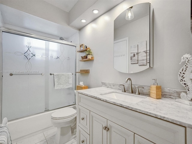 full bathroom with tile patterned floors, vanity, toilet, and combined bath / shower with glass door