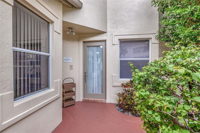 view of exterior entry featuring a patio area