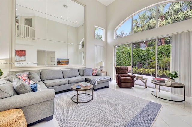 living room featuring a towering ceiling and light tile patterned floors