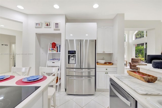 kitchen featuring white cabinets, light tile patterned floors, and stainless steel appliances