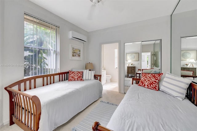 carpeted bedroom featuring a wall unit AC, ensuite bathroom, a closet, and ceiling fan