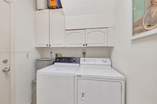 laundry area with washer and clothes dryer and cabinets