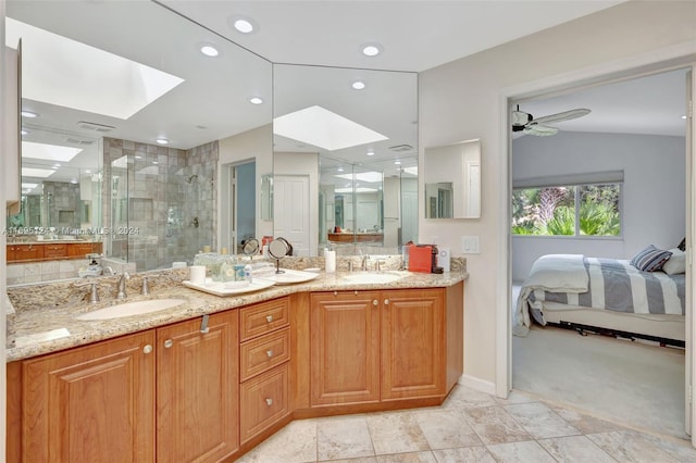 bathroom featuring vaulted ceiling with skylight, vanity, ceiling fan, and walk in shower