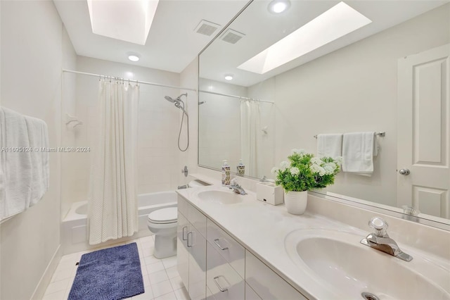 full bathroom with vanity, a skylight, tile patterned flooring, toilet, and shower / tub combo