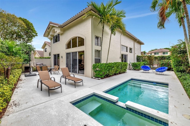 back of house with a patio and a pool with hot tub