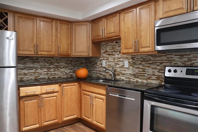 1420 Brickell Bay Dr Unit 1506D, Miami, FL 33131 - kitchen featuring stainless steel appliances, dark stone countertops, decorative backsplash, and light wood-style flooring